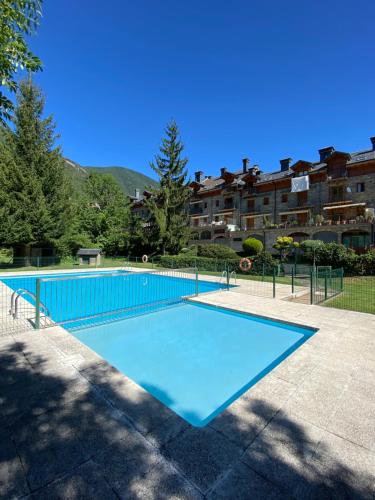 a large blue swimming pool in front of a building at BUENAVISTA2 in Biescas