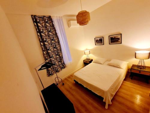 Un dormitorio pequeño con una cama y una ventana. en Le Marty 1, en Carcassonne