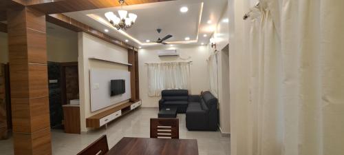 a living room with a tv and a couch and a table at The Candy Studio in Rānchī