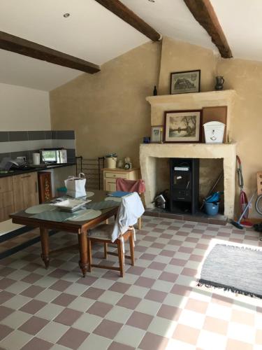 un salon avec une table et une cheminée dans l'établissement La Bergerie, à Bourg