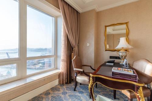 a hotel room with a desk and a window at The Castle Hotel, a Luxury Collection Hotel, Dalian in Dalian