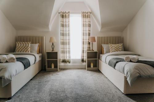 2 camas en un dormitorio con ventana en Alice - spacious 3 bedroom house contractor accommodation, en Sunderland