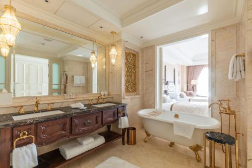 a bathroom with a large mirror and a tub and a bed at The Castle Hotel, a Luxury Collection Hotel, Dalian in Dalian