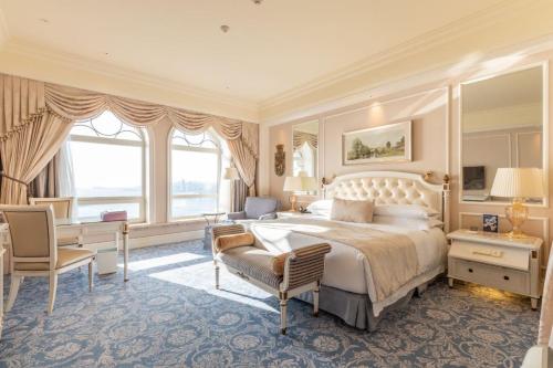a large bedroom with a large bed and a desk at The Castle Hotel, a Luxury Collection Hotel, Dalian in Dalian