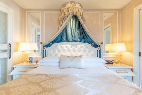 a bedroom with a large bed with a blue canopy at The Castle Hotel, a Luxury Collection Hotel, Dalian in Dalian