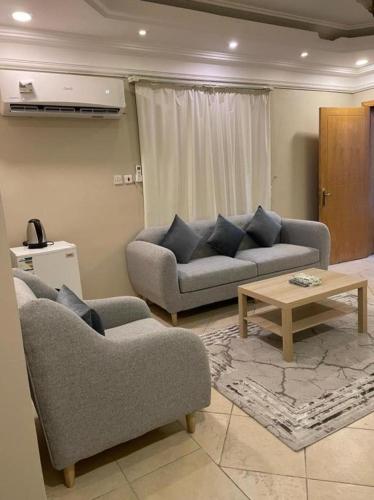 a living room with two couches and a coffee table at ليالي البندقية in Al Khobar