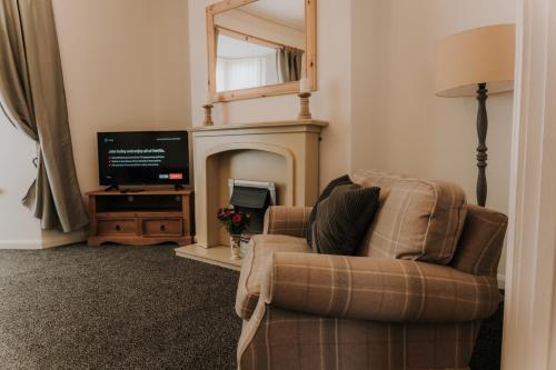 uma sala de estar com uma cadeira e uma televisão em Alice - spacious 3 bedroom house contractor accommodation em Sunderland