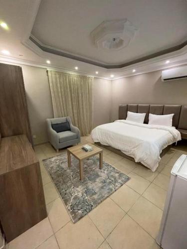 a bedroom with a bed and a chair and a table at ليالي البندقية in Al Khobar