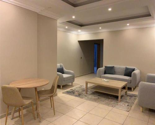 sala de estar con sofá, mesa y sillas en ليالي البندقية en Al Khobar