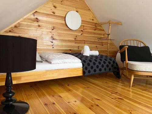 a bed in a room with a wooden wall at NEON Apartman Csopak Balaton, large botanical garden, bicycles, pet&family friendly, outside kitchen, in Csopak