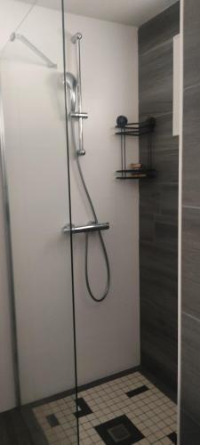 une douche dans une salle de bain avec une porte vitrée dans l'établissement Maison moderne, à Jublains