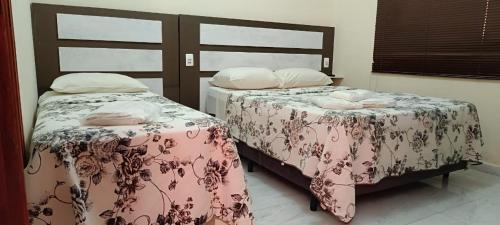 two beds sitting next to each other in a room at La Palma Hotel Fazenda in Indaiatuba