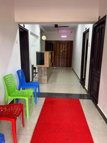a hallway with colorful chairs and a red carpet at SAN BEACH RESIDENCY in kāraikāl