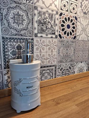 a white soap dispenser in front of a tile wall at Frida Firenze in Florence