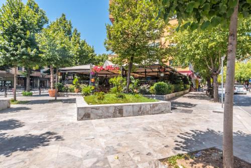 un parco alberato di fronte a un edificio di Piazza Luxury Apartments a Tirana