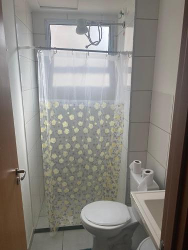 bagno con tenda doccia e servizi igienici di Ap térreo a Uberlândia