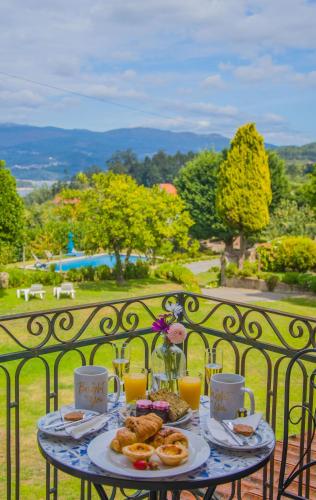 a table with food and drinks on a balcony at Solar Alegria in Ribeiradio
