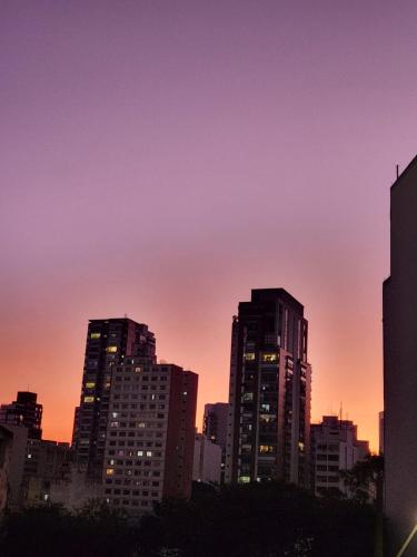 a city skyline with tall buildings at sunset at Fujima Hostel in Sao Paulo