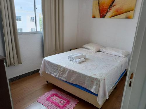 a small bedroom with a bed with white sheets at Apartamento inteiro próximo aeroporto de Confins in Vespasiano