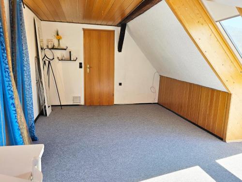 an attic room with a door and a window at Wohnung mit Privtbad in Gaggenau