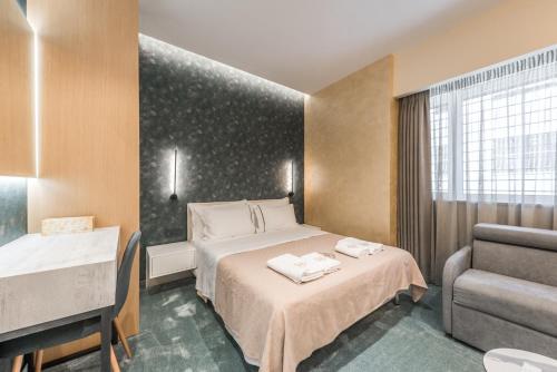 Pokój hotelowy z łóżkiem i krzesłem w obiekcie Piazza Luxury Apartments w Tiranie