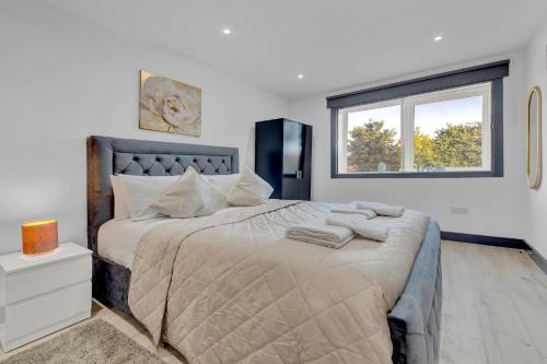 a bedroom with a large bed with towels on it at Captivating 1-Bed Studio in Feltham in Feltham
