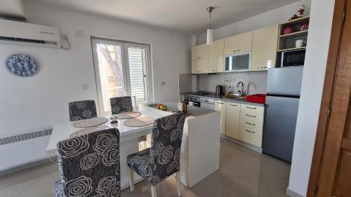 a kitchen with a counter with chairs and a refrigerator at Chic apartment in the City Center by the sea in Tivat