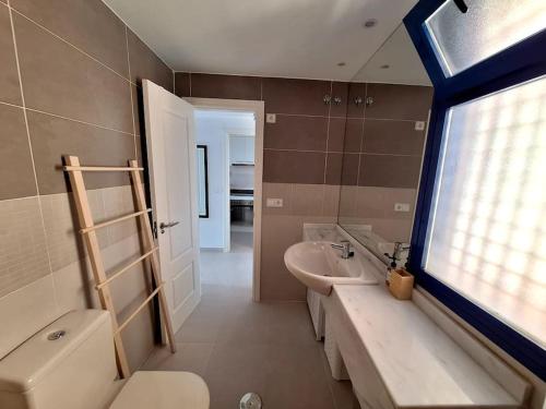 a bathroom with a sink and a toilet and a window at Sea view cozy apartment La Tanita in Mojácar
