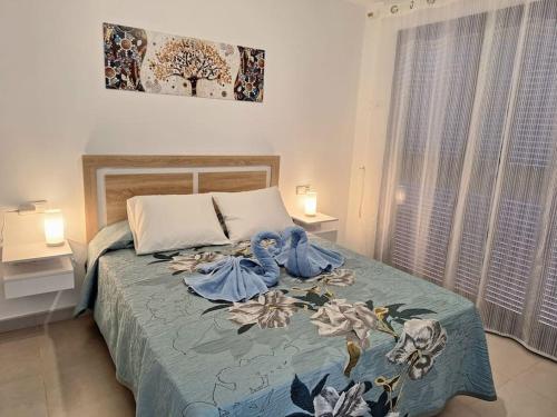 a bedroom with a bed with a blue blanket at Sea view cozy apartment La Tanita in Mojácar