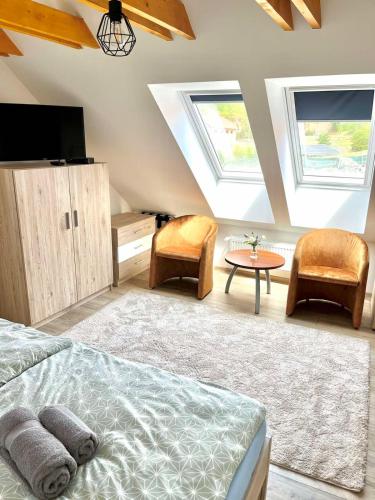 a bedroom with a bed and a table and skylights at Barkland Apartman in Tarcal