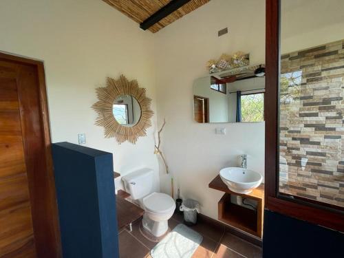 a bathroom with a toilet and a sink at Four Trees Jungle Lodge in San Juan del Sur