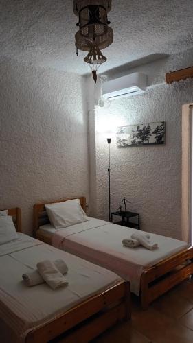 two beds sitting next to each other in a room at Mini mountain view _ next to the sea in Possidi