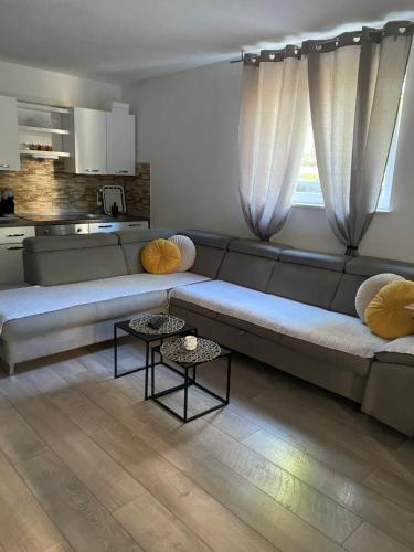 a living room with a couch and a kitchen at Gabine - Self Check-in in Kaštela