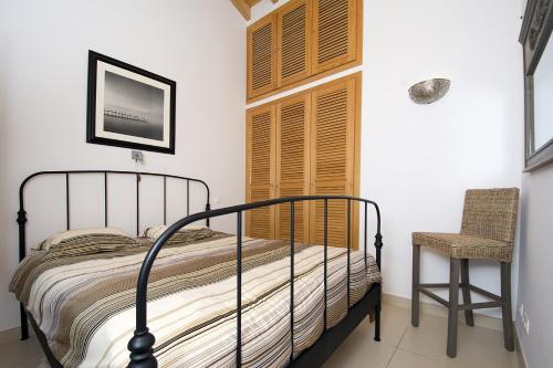 1 dormitorio con 1 cama y 1 silla en Casa Sereia Mar, en Salema