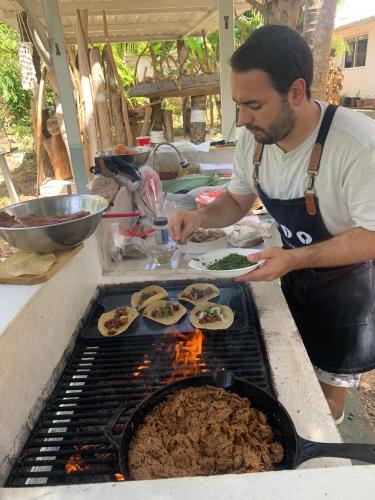 a man is preparing food on a grill at Casa de las Flores tropical in San Andrés
