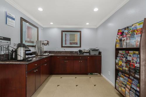 a kitchen with wooden cabinets and a counter top at Motel 6 Carlsbad, Ca- North in Carlsbad