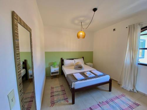 a small bedroom with a bed and a mirror at Casa Petrópolis in Petrópolis