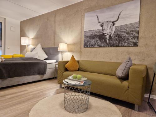 ein Wohnzimmer mit einem Sofa und einer Kuh an der Wand in der Unterkunft Urban City Lifestyle Appartement in Bielefeld