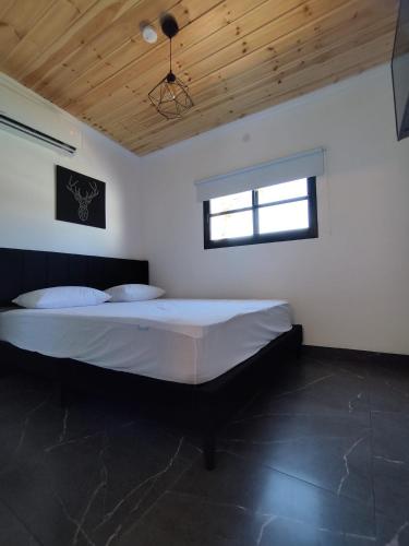 a bedroom with a large bed with a wooden ceiling at סוויט ריזורט בגורן in H̱osen
