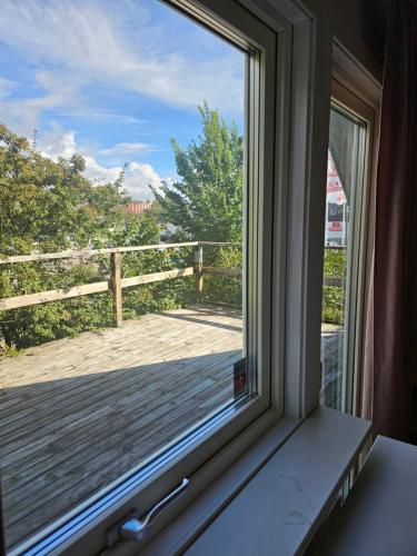 ventana con vistas a una terraza de madera en Villa Sandgatan, en Falkenberg