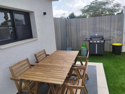 - une table et des chaises en bois sur une terrasse avec barbecue dans l'établissement סוויט ריזורט בגורן, à H̱osen