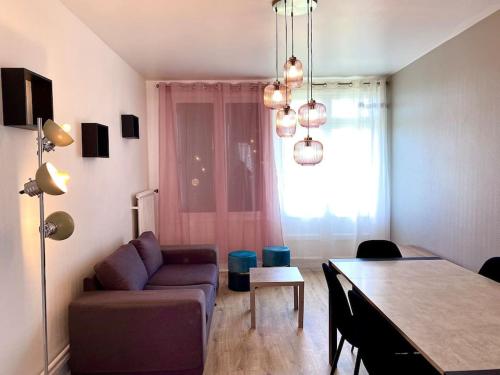 un soggiorno con un divano e un tavolo di Bel appartement centre ville de Vierzon a Vierzon