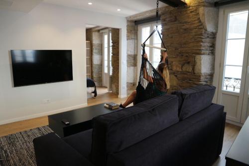 una persona sosteniendo una hamaca en un sofá en una sala de estar en Apartamentos FOROPLAZA, en Lugo