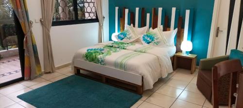 1 dormitorio con 1 cama con pared azul en Villa Mia en Abiyán