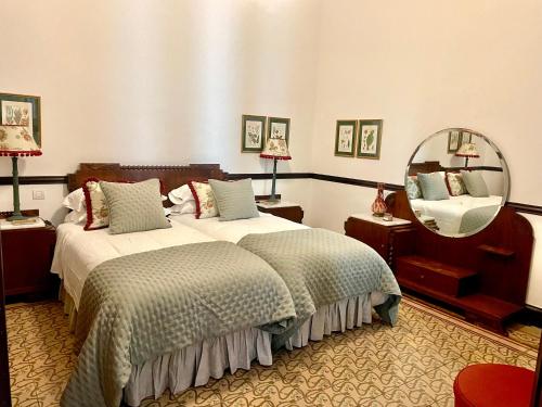 una camera d'albergo con due letti e uno specchio di Casa Colonial El Indiano a Las Palmas de Gran Canaria