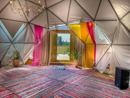 una habitación con una tienda de campaña con una alfombra grande en Alternativa Glamp, en Ma‘yan Ẕevi