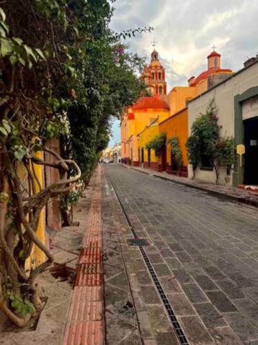 an empty street in a town with a building at The stones house in the Historic Downtown in Querétaro