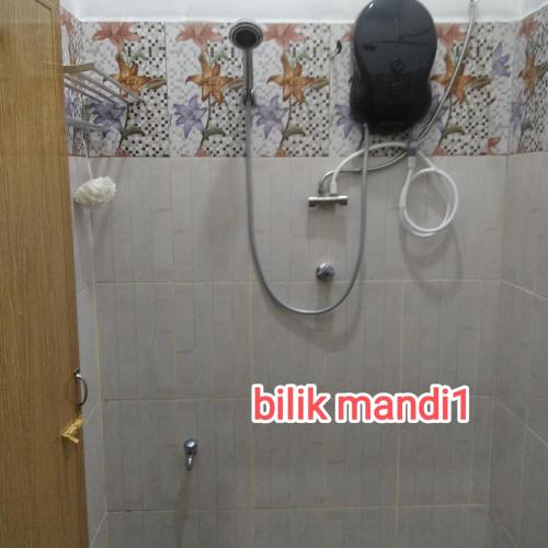 a shower with a shower head in a bathroom at Raptronics Homestay Kampung in Kota Bharu
