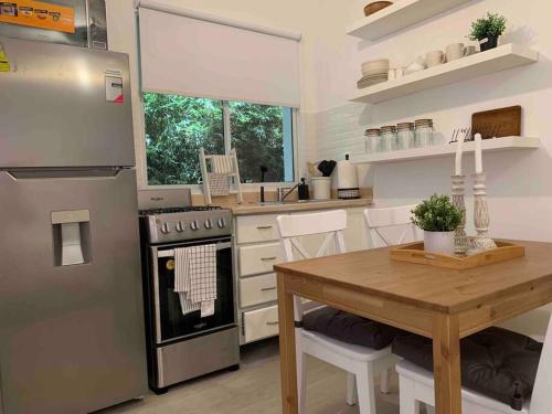 uma cozinha com uma mesa de madeira e um fogão forno superior em Cozy Apartment at The Village em Punta Cana