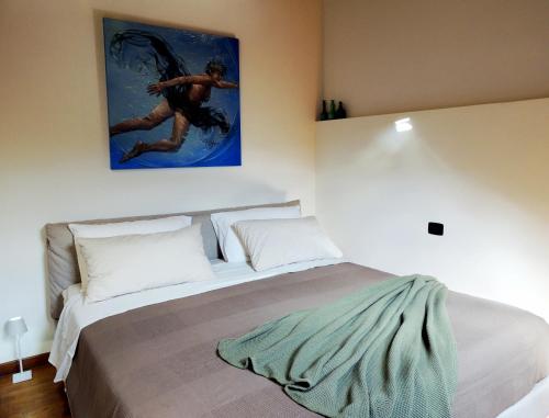 um quarto com uma cama com um quadro na parede em La piazza al lago - A 40 metri dal lago em Mandello del Lario